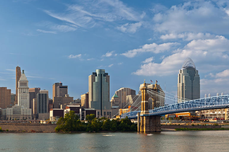 Cincinnati skyline and historic John A. Roebling suspension bridge cross Ohio River.